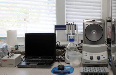 В центре коллективного пользования "Геномика" все готово к работе. На одном из рабочих столов установлен спектрофотометр для анализа ДНК и лабораторная центрифуга, которая отделяет различные по консистенции и плотности вещества.